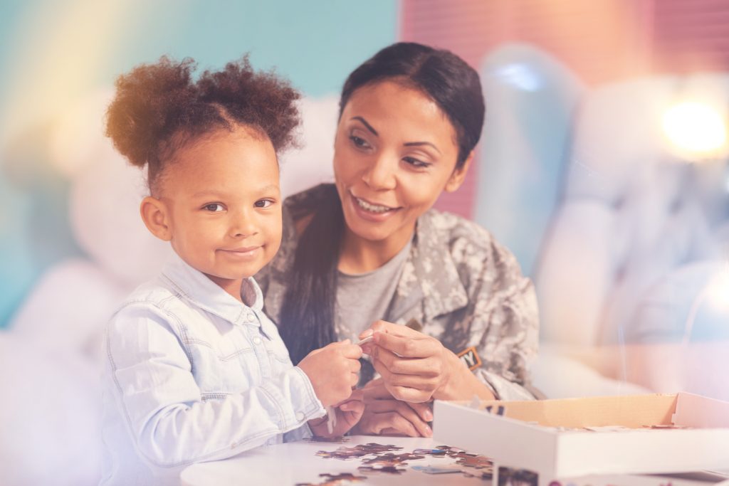 Military mother and daughter doing a puzzle together